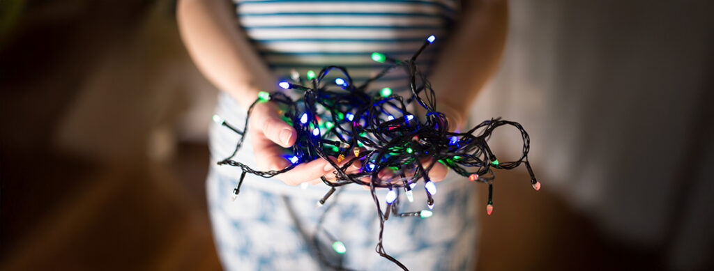 woman holding christmas lights